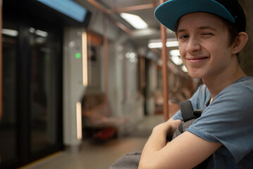 smiling 12 year old boy with backpack in train carriage, subway, metro	