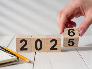 Hand changing wood blocks from 2025 to 2026