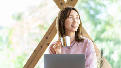 カフェでパソコンを使って仕事をする女性