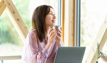 カフェでパソコンを使って仕事をする女性