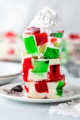 Jelly dessert squares stacked with whip cream on top.