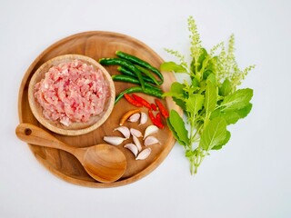Minced pork, Fersh chilies, garlic placed on a wooden tray with basil leaves.