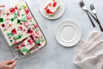 A hand serving up a portion from a sweet homemade jelly dessert.