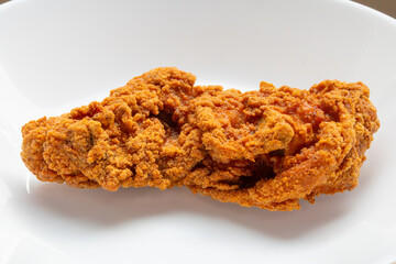 crispy fried chicken on white plate close up