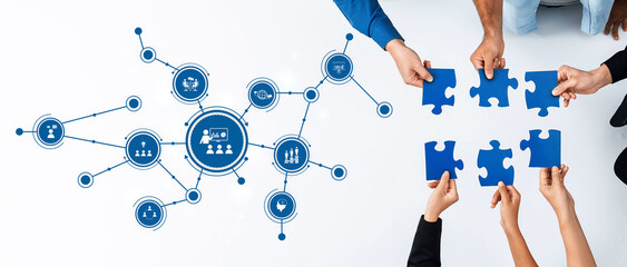 This image depicts a collaborative environment with hands grasping puzzle pieces, symbolizing...