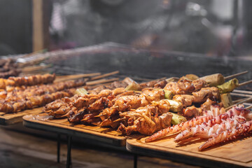 A variety of barbecue meat skewers are being sold at the food stall.