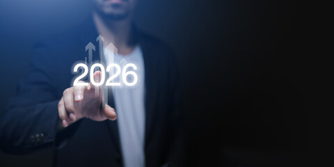 Businessman hand presenting with digital 2026, upward arrows. Futuristic concept of business...