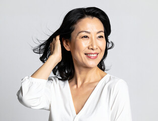 笑顔で髪を触る中年女性