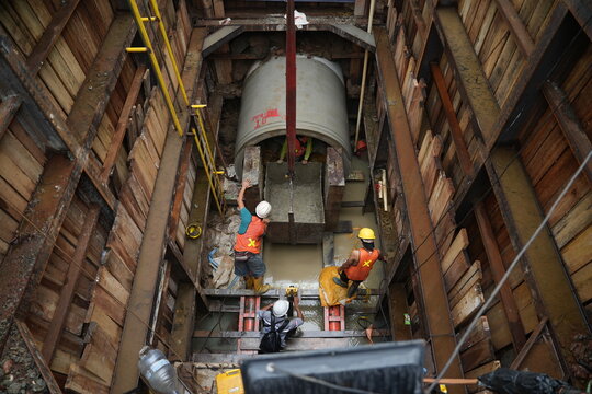 View from above Some workers do pipeline repair work with complete safety equipment. a large pipeline network and also an underground cable network can be seen