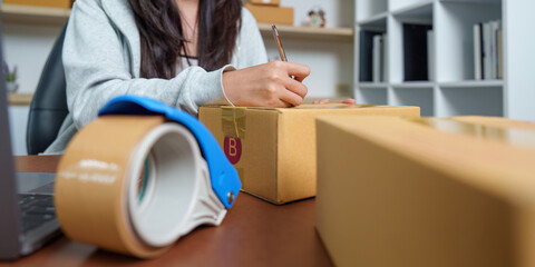 E-commerce: Woman labeling packages for online business
