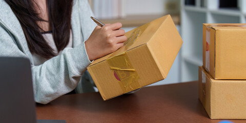 E-commerce: Woman signing packages while managing online orders
