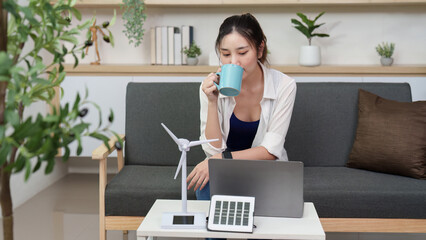 Sustainable Living. Woman enjoying coffee while working on renewable energy solutions.