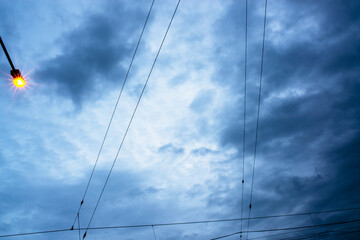 Fototapeta premium Moody Overcast Sky with Illuminated Street Light and Power Lines