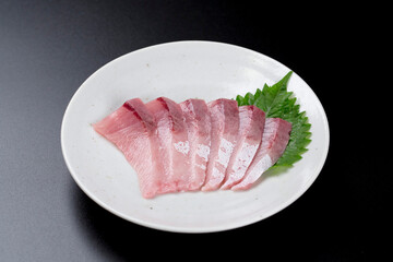 皿に盛られたブリのお刺身 黒背景