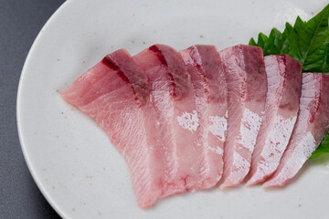 皿に盛られたブリのお刺身 黒背景