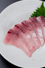 皿に盛られたブリのお刺身 黒背景