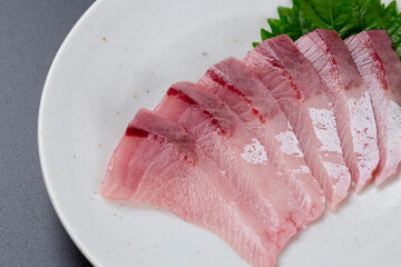 皿に盛られたブリのお刺身 黒背景