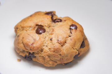 Freshly baked chocolate chip cookie on a white plate