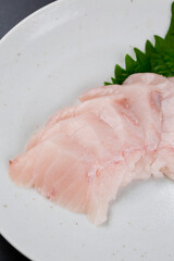 皿に盛られたサワラのお刺身 黒背景