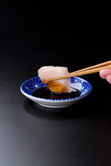 皿に盛られたサワラのお刺身 黒背景