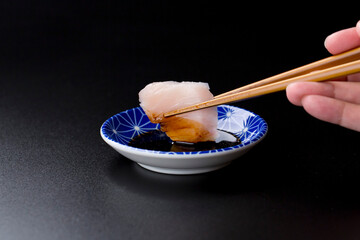 皿に盛られたサワラのお刺身 黒背景