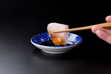 皿に盛られたサワラのお刺身 黒背景