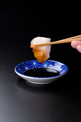 皿に盛られたサワラのお刺身 黒背景