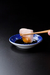 皿に盛られたサワラのお刺身 黒背景