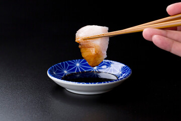 皿に盛られたサワラのお刺身 黒背景