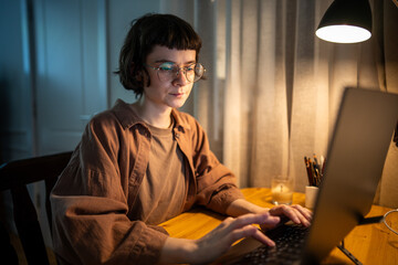 Weary young woman working on laptop during late night, fatigue and stress problems. Female...