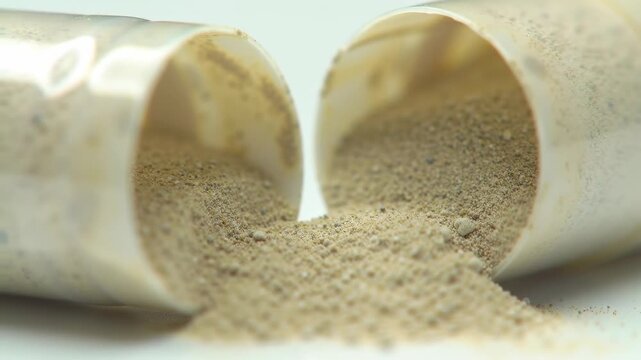Macro shot of an open capsule spilling granular contents