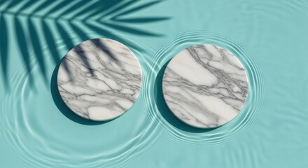 Two round marble coasters floating on rippling turquoise water with palm leaf shadow