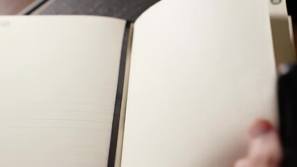 Open book with blank pages and hand turning the next page
