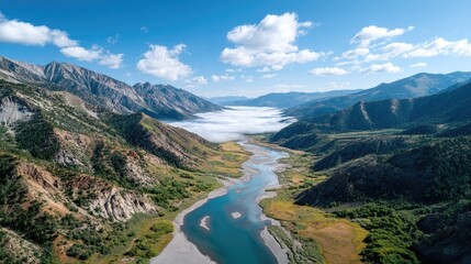 Majestic Mountain Valley With A Winding River Under A Blue Sky With Wispy Clouds And Morning Fog Settling Over Water