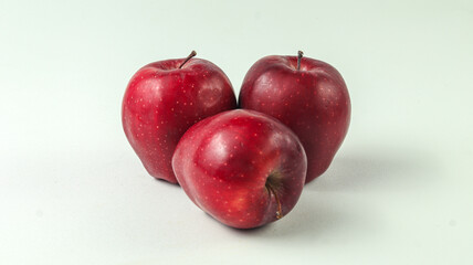 three red apples on a white background
