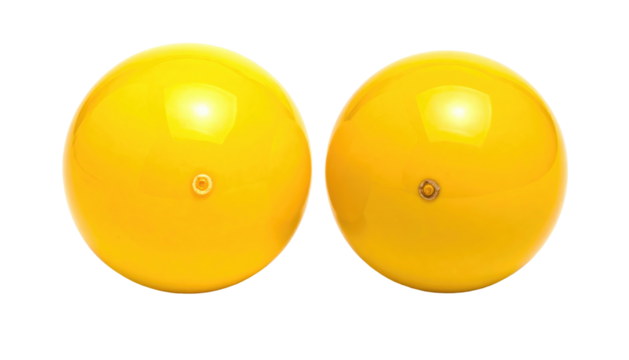 Two bright yellow balls with central air valves, side-by-side on a black background, reflecting light
