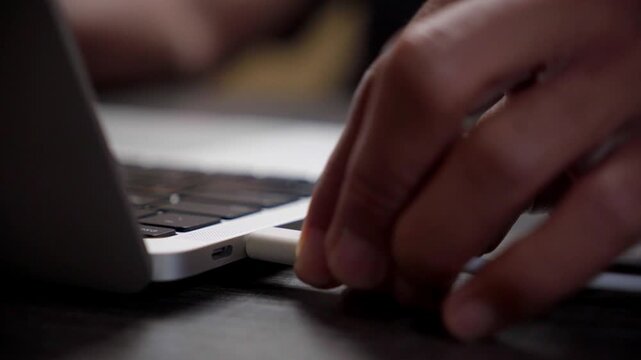 Macro Shot of a Hand Plugging a USB-C Cable into a Modern Grey Laptop Port