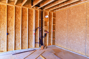 Wooden framing plumbing details interior of building under construction.