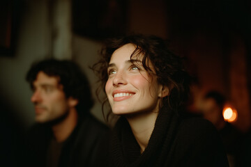 Young woman smiling indoors with warm lighting and curly hair