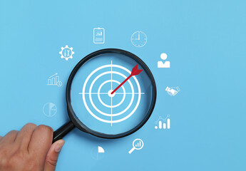 Magnifying glass focus to target icon which for planning development leadership and customer target...