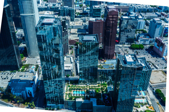 Drone aerial photo of skyscrapers in downtown Los Angeles California featuring PwC Tower and surrounding office buildings under clear blue sky on a sunny day