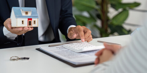 Real Estate Agent Calculating Costs. Client evaluating property investment.