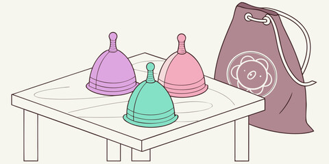Colorful eco-friendly menstrual cups on table with drawstring bag  