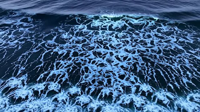 Ocean wave foam cresting with energy in deep, vibrant blue water