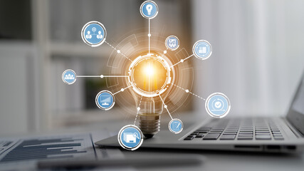 A vibrant light bulb emitting energy symbolizes ideas and innovation, surrounded by technology icons, set on a laptop in a modern office, representing creativity and solutions. Crux