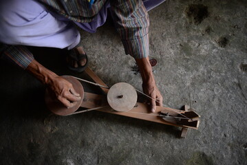 Traditional hand charkha used for spinning silk and khadi, symbolizing Indian craftsmanship, self-reliance, and sustainability. A wooden spinning wheel turning natural fibers into fine threads.
