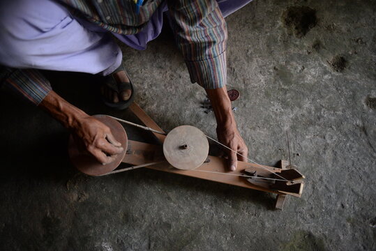 Traditional hand charkha used for spinning silk and khadi, symbolizing Indian craftsmanship, self-reliance, and sustainability. A wooden spinning wheel turning natural fibers into fine threads.
