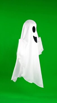A smiling white ghost floats against a vibrant green background