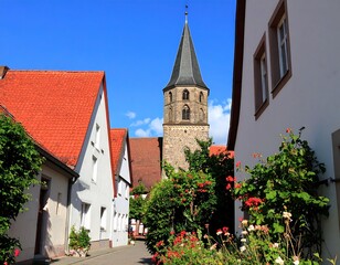 Sunny village street with white houses and church