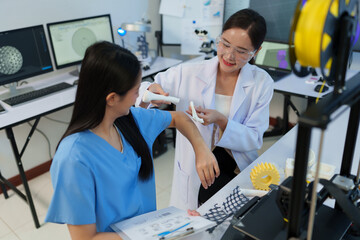 Researchers are working with a 3D printer to print clear, white plastic models using cutting-edge,...